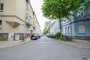 una calle vacía con coches estacionados a los lados de los edificios en cruwzo I Apartment Rüttenscheid- Grün & Zentral, en Essen
