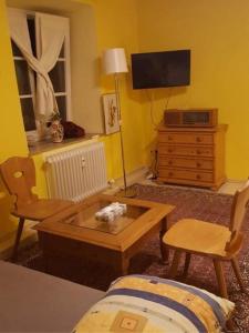 a living room with a tv and a table and chairs at Am-Berg Ferienwohnung in Bad kohlgrub in Bad Kohlgrub