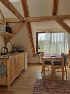 a kitchen with a table and chairs in a room at Mazurski dworek przy Jeziorze in Dworackie