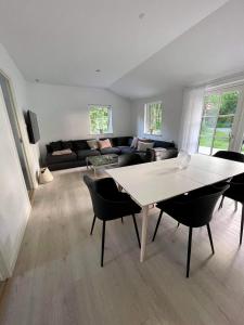 een woonkamer met een tafel en stoelen en een bank bij Sommerhus Mossø in Skanderborg