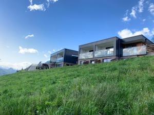 a building on top of a grassy hill at AGRITUR SEDICI - Bed and Breakfast in Tenna 