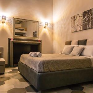 a bedroom with a bed with a fireplace and a mirror at La Rondine in Tagliacozzo