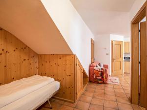 a bedroom with a bed and a chair at Ciasa Lino Rotic in Pozza di Fassa