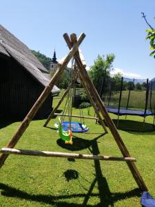 een houten schommel in een tuin bij Apartma in soba pri Bregarju in Bohinj +52 foto's