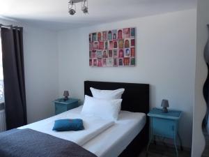 a bedroom with a bed with two blue tables at Haus am Burggraben in Hinte +7 photos