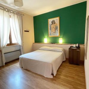 Duas camas num quarto com uma parede verde em Motel 70-Hotel em San Nazzaro