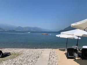 a beach with umbrellas overlooking the ocean at Hotel La Sacca in Stresa