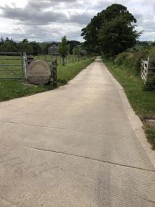 un camino vacío con una señal en la distancia en Millers Cottage, en Berwick-Upon-Tweed