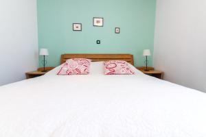 een slaapkamer met een wit bed met 2 kussens erop bij Villa Melita in Opatija