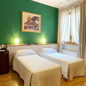 two beds in a room with green walls at Motel 70-Hotel in San Nazzaro