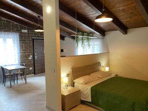 una camera con un letto verde e un tavolo di Masseria Moriello - lago di Telese a Telese