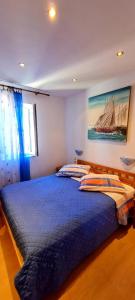 a bedroom with a blue bed with a sailboat on the wall at Bed & Breakfast Dionis Vis in Vis