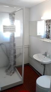 a bathroom with a glass shower with a sink at Hotel Nordlys in Oqaatsut