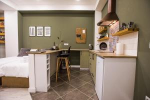 a bedroom with a bed and a kitchen with a desk at hotelise I Bells-Of-Ireland Apartment in Yerevan