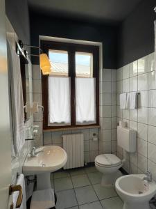 ein Bad mit einem Waschbecken, einem WC und einem Fenster in der Unterkunft Motel 70-Hotel in San Nazzaro