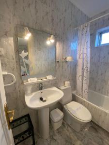 a white bathroom with a sink and a toilet at Hospedaje Oreña in Oreña +65 photos
