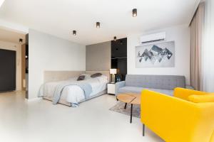 um quarto com uma cama e um sofá amarelo em Studio Silesian Vip City Centrum Free Parking em Zabrze