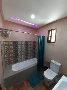 a bathroom with a toilet and a tub and a sink at Superbe villa marrakech in Marrakesh