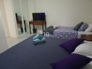 a bedroom with two beds and a desk and a table at Hospedaria do Almargem in Quarteira