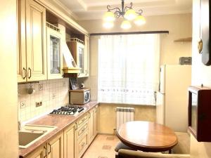 cocina con mesa, nevera y ventana en Guest House Aleksina, en Lazarevskoye