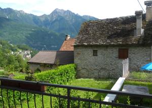 Maison à la coque في باشينو: منزل حجري قديم مع جبال في الخلفية