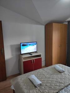 een slaapkamer met een bed en een flatscreen-tv bij Apartment Stefan in Ohrid