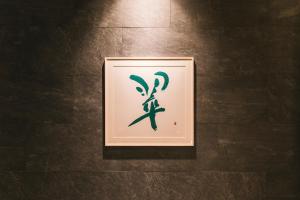 a framed picture of a lizard on a wall at Hotel Yaenomidori Tokyo in Tokyo