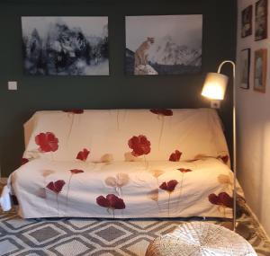 a bed with red flowers on it in a room at Maison à la coque in Baceno