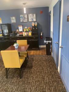 a dining room with a table and yellow chairs at Fairview Inn - Greensboro Airport in Greensboro