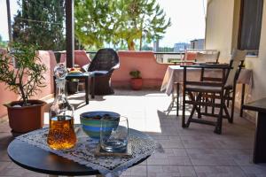 a table with a bottle and a bowl on a patio at Gorgona Apt in Heraklio Town