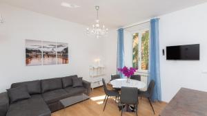 ein Wohnzimmer mit einem Sofa und einem Tisch mit Stühlen in der Unterkunft Karan's Aparment Rental in Rome in Rom