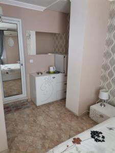 a small bathroom with a mirror and a sink at Guest House Konomaevi in Sozopol