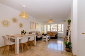 uma sala de estar com uma mesa e um sofá em WintowinRentals Teatinos, Metro, Free Parking & Pool. em Málaga
