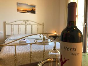 RilievoにあるB&B SiciliAnticaのベッドサイドのテーブルに座るワイン1本