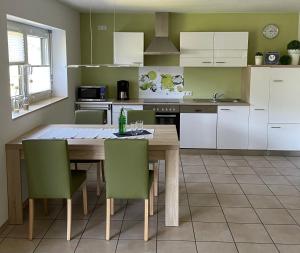 a kitchen with a wooden table and green chairs at Ferienwohnung Pusteblume in Cochem