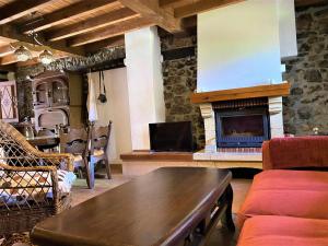 a living room with a table and a fireplace at La Casina de Orfeo Cuenco Cangas de Onís VV-1901-A in Cangas de Onís