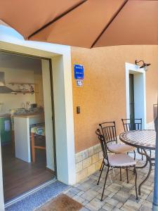 a patio with a table and chairs and a kitchen at Bed & Breakfast Daniela in Veleniki
