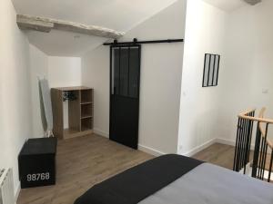 1 dormitorio con cama y puerta negra en Bourg superbe appart avec vue magnifique, en Bourg-sur-Gironde