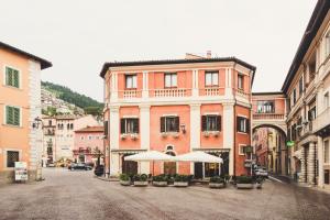 a street with a building with umbrellas in front of it at La Rondine in Tagliacozzo