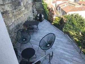 a patio with chairs and tables on a balcony at Bourg superbe appart avec vue magnifique in Bourg-sur-Gironde
