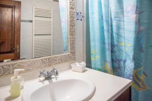 a bathroom with a sink and a shower curtain at Andros traditions house in Kathikas