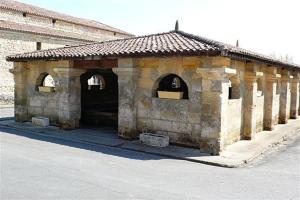 a small stone building with two arches on a street at Bourg superbe appart avec vue magnifique in Bourg-sur-Gironde