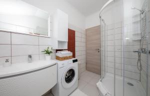 a bathroom with a washing machine and a shower at Apartments Luka in Rab +70 photos