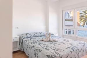 un dormitorio con una cama con un animal de peluche en Apartamento Fisterra con vistas al mar, en Finisterre