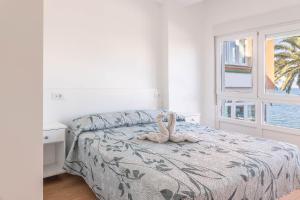 Un dormitorio con una cama con un animal de peluche encima. en Apartamento Fisterra con vistas al mar, en Finisterre