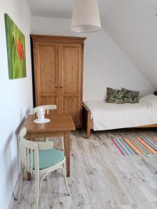 ein kleines Zimmer mit einem Tisch und einem Bett in der Unterkunft Vadkert Vendégház in Dörgicse