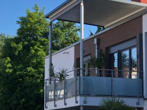 una casa con un balcón con plantas. en Seestern Apartment en Friedrichshafen