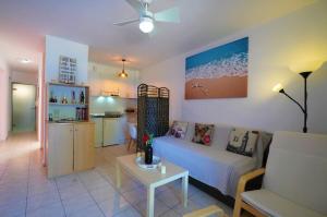 a living room with a couch and a kitchen at Mandy Seafront Studios in Zakynthos Town
