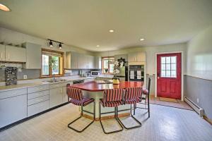 a kitchen with a red door and a table and chairs at Lakeside Berkshires Home Near Hiking and Skiing! in Lanesborough