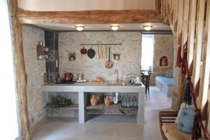 a kitchen with a sink and a stone wall at Laini Guest Houses in Koulkouthianá